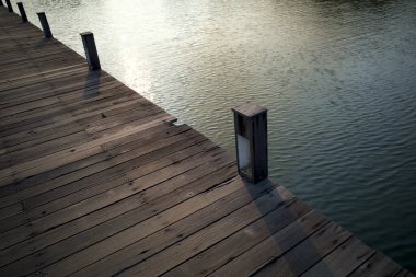 Semarang, Central Java, Endonezya 'da yapay bir göl üzerinde eski ahşap bir köprü..