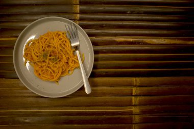 Siyah bambu masasında beyaz tabakta spagetti..
