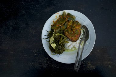 Pirinç, kızartılmış vatoz balığı ve sebzeler Endonezya mutfağı, Endonezya yemekleri eski ahşap bir masada..