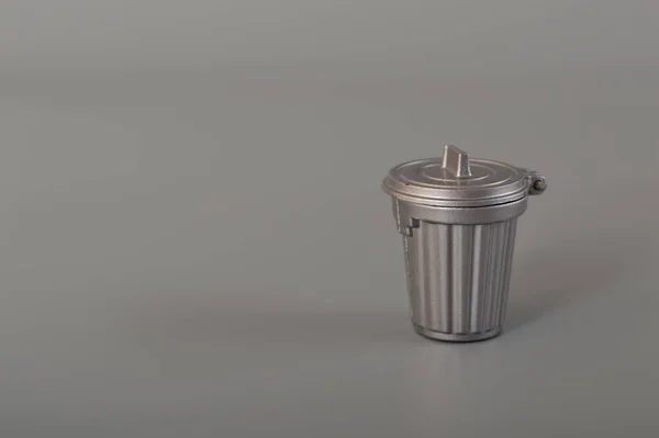 Grey trash can isolated on a grey background. Copy space for the text.