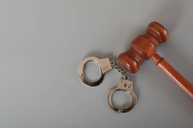 Hakim tokmak ve kelepçe gri bir arkaplanda izole edilmiş. Metin için alanı kopyala. Tutuklama ve suç kavramı.