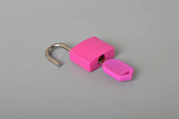 グレーの背景にピンクの南京錠とキーが隔離されています テキストのスペースをコピー — ストック写真