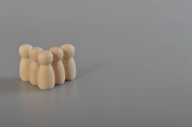 Tahta bebek figürleri grup üyelerinin arasında duruyor. İnsanlar bir grup halinde birleşti. Konsolidasyon, işletme yönetimi, bir ekip kurmak, çalışanlar, insan kaynakları, personel toplama.