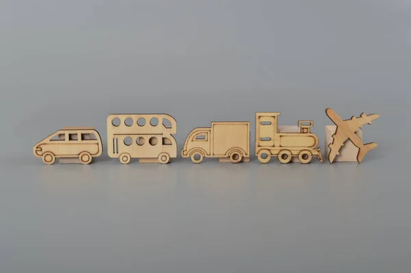 Wooden toy vehicles isolated on a grey background. concept for childhood development, minimalist nostalgic toys and educational play time