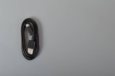Gri bir arkaplanda cep telefonu kablosu izole edildi.