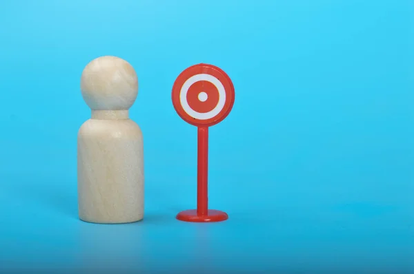 Wooden doll figure and target sign. Target customers, audience outreach, sales generation.