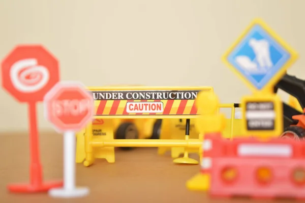 Under Construction warning sign symbol with blurred background.