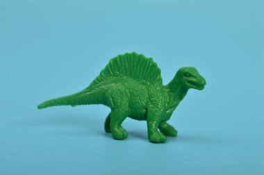 Toy spinosaurus dinosaur isolated on a blue background