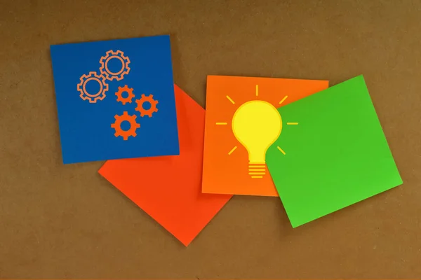 Colorful papers with light bulb and gears. Innovation and ideas concept.
