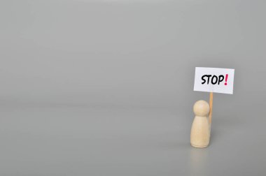 Bırakma zamanı geldi artık. Tahta figürlerin elinde dur işareti olan yakın plan görüntüsü duruşmayı durdurma ve bitirme zamanının geldiğini gösteriyor..