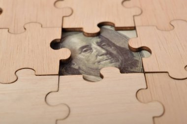 Kayıp yapboz üzerindeki para banknotlarının bir kombinasyonu gelirleri ve yüzdelik yatırımları gösteriyor. Görüntü, emeklilik, tazminat fonu, yatırım, temettü vergisi ve borsa gibi çeşitli mali yönleri temsil ediyor..