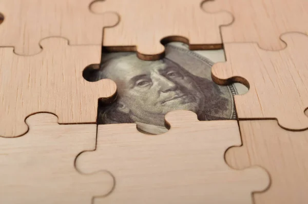 stock image A combination of money banknotes on missing jigsaw puzzle depicts income and return on investment in percentage. The image represents various financial aspects, such as retirement, compensation fund, investment, dividend tax, and stock market.