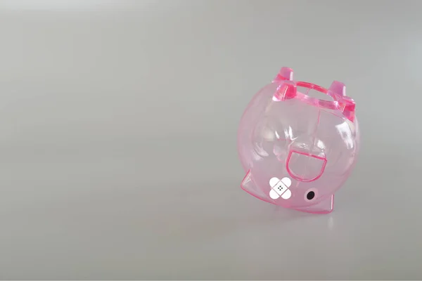 Pink piggy bank with plaster. Finance background concept for economic recession, depression or bankruptcy