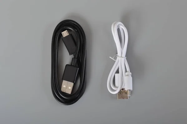Black and white usb cable for smartphone on grey background