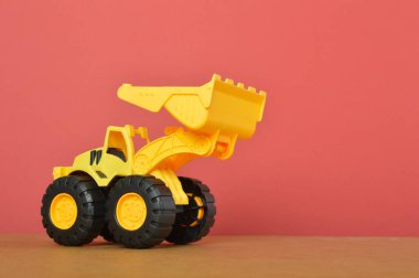 Kırmızı arka planda izole edilmiş plastik kepçe çekici oyuncak