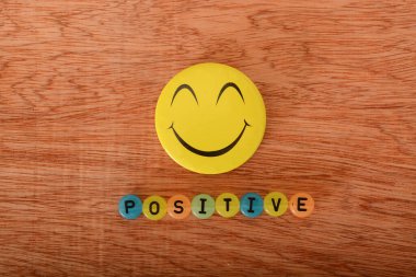 A happy face smile with text POSITIVE. clipart