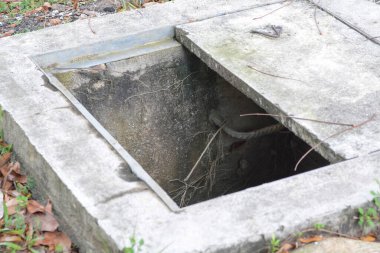 Kanalizasyon kapağı olmadığı için şehir caddesi boyunca yürüyen insanlar için tehlike arz eden açık bir kanalizasyon kapağı var. Onarım çalışması gerekiyor..