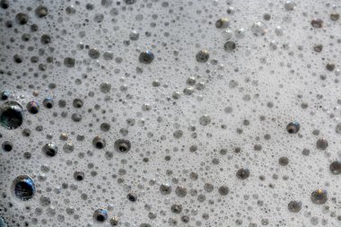 Sarı yıkama sıvısında baloncukların yakın plan görüntüsü kabarcıklı bir zemin oluşturur..