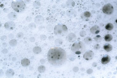 Sarı yıkama sıvısında baloncukların yakın plan görüntüsü kabarcıklı bir zemin oluşturur..