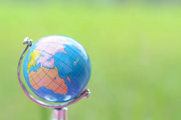 World globe on the green grass. A healthy ecology for planet Earth, ensuring a prosperous future for our generation. Let\'s unite to save the world.