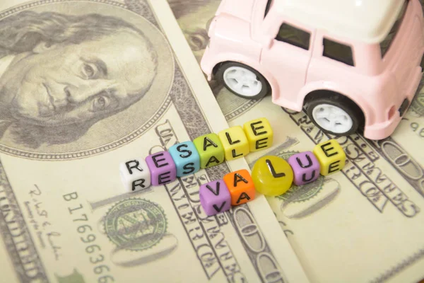 İçinde minyatür dolar banknotları olan oyuncak arabaların yer aldığı fotoğraflar, araba satış fiyatlarındaki potansiyel kârları simgeliyor.