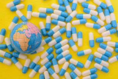 İlaç hapları ve dünya küresi küresel sağlık için farklı perspektifler sunmaktadır.