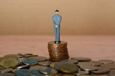 İş adamı, bir yığın paranın üzerine tünemiş, geriye bakmış, geçmişteki deneyimlerinden bilgelik çizmiş, onu şimdiki başarısına götüren yolculuğu düşünüyordu..