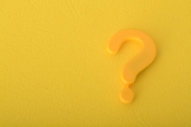 Sarı arka planda izole edilmiş soru işareti, insanları araştırma yapmaya ve bilgiyi araştırmaya çağıran bir işaret görevi görüyor..