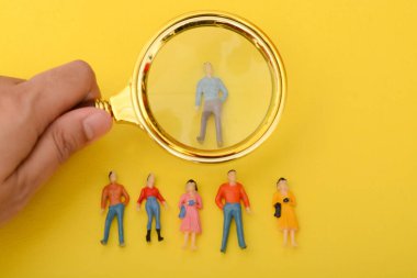 The group of staff, armed with a magnifying glass, scoured the job applications, searching for the ideal candidate to hire. clipart