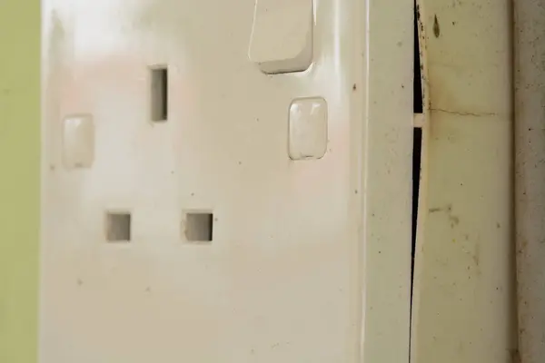 A damaged electrical domestic power socket with visible cracks poses a serious risk of electrocution or fire