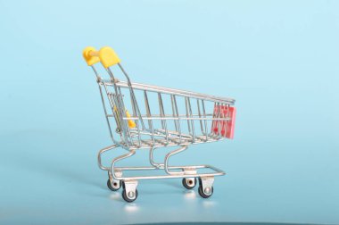 Süpermarket tramvayı tüketici özerkliği ve seçiminin bir sembolü olarak duruyor, ürünlerle doldurulmaya hazır.