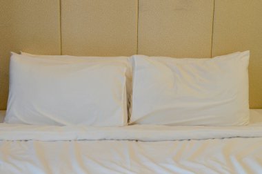 Two pillows are on the bed in the hotel room. They add a touch of comfort and luxury for a restful night's sleep. clipart