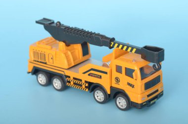 Görüntü, yaratıcı oyun ve inşaat temalı aktiviteler için tasarlanmış, hareket ettirilebilir kancası olan sarı oyuncak bir vinç kamyonunu tasvir ediyor..