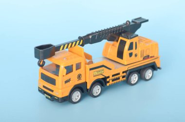 Görüntü, yaratıcı oyun ve inşaat temalı aktiviteler için tasarlanmış, hareket ettirilebilir kancası olan sarı oyuncak bir vinç kamyonunu tasvir ediyor..