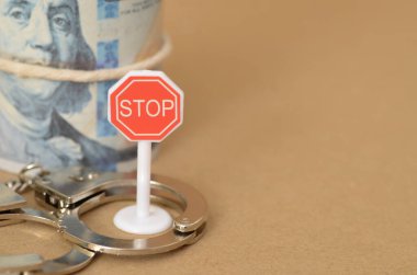 Yasadışı banknotlar şeklinde paranın peşinde koşarken ortaya çıkan tehlikeyi işaret eden dur işareti gibi açık bir uyarı, kaçınılmaz suça giden bir yol..
