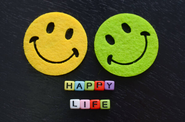 Веселые улыбающиеся лица и слова "Счастливая жизнь" передают мощное послание о важности позитивного мышления в достижении счастья.