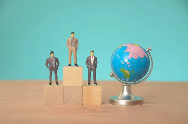 stock image With a world globe, a row of businessmen stood tall, representing their shared vision of global influence and collaboration.