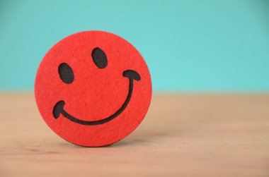 Gülen yüzün basit tasarımı, cesur siyah çizgisi ve neşeli ifadesiyle, evrensel olarak mutluluk ve pozitifliğin sembolü olarak kabul edilir..