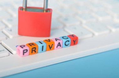 Bir dizi harf bloğunun üzerinde duran kırmızı asma kilit 