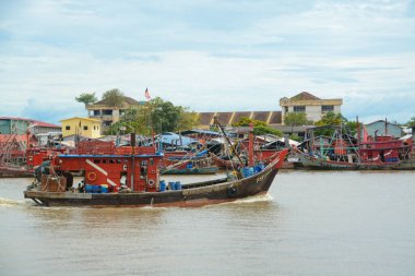 Kedah, Malezya: 17 Ekim 2024: Resim, renkli tekneleri ve hareketli faaliyetleriyle geleneksel bir balıkçı köyünün özünü yakalıyor.