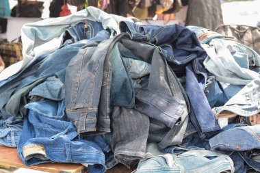 Klang, Malaysia: October 6th, 2024- The image shows a pile of used denim jeans in various colors and styles. clipart