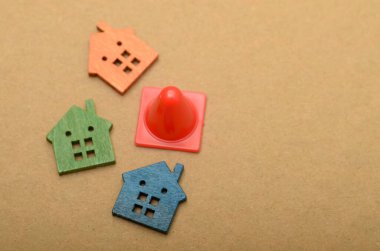 Bir trafik konisi ve birkaç evin görüntüsü, emlak piyasasındaki potansiyel bozulma veya zorluklar kavramını sembolize etmektedir..