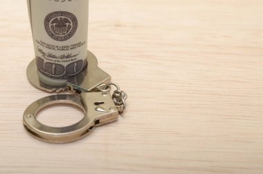 a roll of cash bound by handcuffs, creating a striking metaphor for the constraints and limitations that money can sometimes impose. clipart