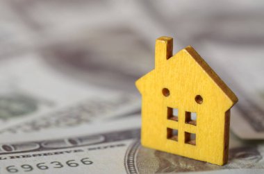 Dolar Faturaları Üzerinde Sarı Tahta Ev Gayrimenkul Yatırım ve Ev Finansmanı Konsepti.