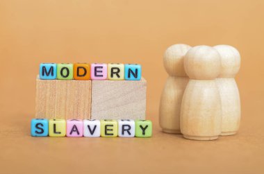 Çağdaş Kölelik Konsepti Renkli Zarlar ve Yüzsüz Ahşap Figürler Gizli Sömürüyü Temsil Ediyor