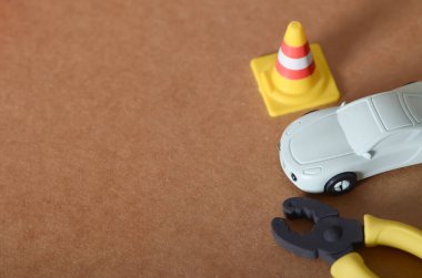 Trafik Konisi ve Kahverengi Yüzeyde Pense olan Oyuncak Araba Arızası Sahnesi