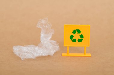 Plastik Atık Geri Dönüşümü: Sarı İşaret Üzerine Temiz Plastik ve Yeşil Sembol