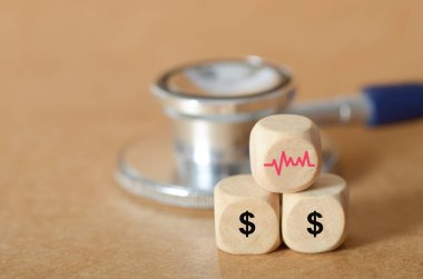 Stetoskop ve ECG ve Dolar İşaretli Tahta Zar kullanarak Sağlık Hizmetleri İfadeleri