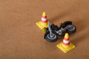 Mini Trafik Konisi ve Oyuncak Motosiklet Depicting Yol Güvenliği Kahverengi Arkaplan Kazası Simülasyonu