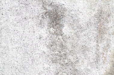 Sert, yıpranmış ve lekelenmiş beyaz beton bir yüzey, endüstriyel temalar için cesur ve soyut bir arkaplan oluşturan gri yamaların benekli bir karışımını sergiliyor..